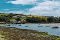 The sunny coast of southern Ireland. Small fishing boats are anchored in Clonakilty Bay at low