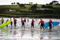 Clonakilty, Ireland - students from a local surfing school take their boards into the water at Inchydoney beach