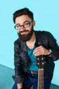 Close Bearded hipster man holding acoustic guitar.