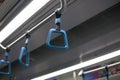 Close of of blue handle hand rail inside subway train.