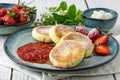 Close cheese pancakes, syrniki, curd fritters with fresh strawberries on plate background