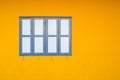 Close Dark Blue Window on Yellow Concrete or Cement Wall