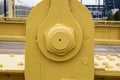 Close detail view of large bolt on a suspension bridge upright recently painted bright yellow