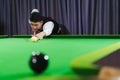 Close-eyed Asian player aiming snooker ball like a pro