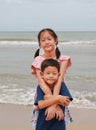 Close eyes smiling happy child on the beach. Asian little boy and young girl at the beach during family summer vacation Royalty Free Stock Photo