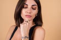 Close fashion portrait of young woman on beige background