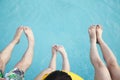 Close on feet on young family in the pool Royalty Free Stock Photo