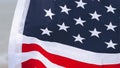 Close up of female hands hold USA flag on the beach near sea waves.