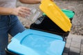 Close of female throwing out in recycling bin clean empty plastic container. Different colour of recycling bins