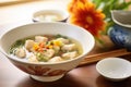 close field of fresh dumplings in a soup with vibrant broth