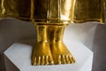 Feet of golden Buddha statue on white stand. Royalty Free Stock Photo