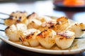 close focus of skewered scallops on a plate