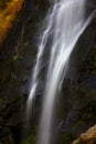 Close focus on smooth flowing water from high rock waterfall Royalty Free Stock Photo