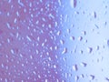 Close focus on water drop on colorful glass. Close focus on water drop on colorful window glass in blue and pink Royalty Free Stock Photo