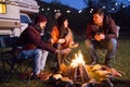 Close friends ejoying the heat from their camp fire