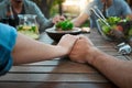 Close friends stick together. two unrecognizable people holding hands around a table outside in a garden. Royalty Free Stock Photo