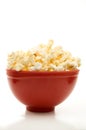 Close Front View of Buttered Popcorn in a Red Bowl Isolated on White