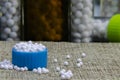 Close image of Homeopathic granules in small bottle cap and some pills scattered on the jute sack surface with blurred white sugar Royalty Free Stock Photo