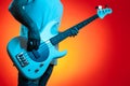 Close-ip image of stylish hipster man play white bass guitar in neon lights. Rock music concept. Royalty Free Stock Photo