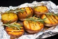 close look at grilled potatoes with rosemary on top of aluminum foil