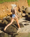 Close luxurious slim girl in blue bikini on the ocean beach. Sexy tanned body, flat stomach, perfect figure.