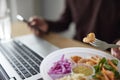 Close Of Man Eating Healthy Lunch At Office Desk Whilst Using Laptop Royalty Free Stock Photo