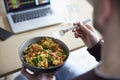 Close Of Man Eating Healthy Vegan Lunch At Office Desk Whilst Using Laptop Royalty Free Stock Photo