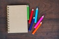 Close note book and color pencil on wooden background