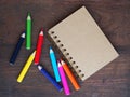 Close note book and color pencil on wooden background
