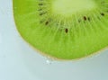 Close-op of kiwi fruit with bubbles. Bright view photo. Kiwi fruit slice in water with bubbles on light background Royalty Free Stock Photo