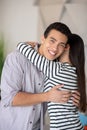 Young man with white-toothed smile hugging a woman. Royalty Free Stock Photo