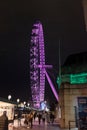 Close and Personal a close view of the London Eye being lit by purple light.