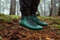 Close photo, feet in the boots of a tourist standing on the ground in the woods