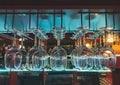 Close photo of glasses in the bar. Crystal clear with blue light on the background of the shelves with the allegor. Glasses hang Royalty Free Stock Photo