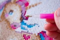 Close photo, macro. process by hands - diamond mosaic for girls magical pink unicorn