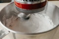 Hand of a young woman who is demonstrating meringue on the mixer whisk near bowl