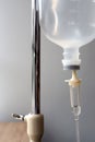A Close photos of a brine bottle hanging on a pole in a hospital on a white background