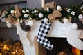 A close picture of beautifully decorated white Christmas socks hanging on fireplace waiting for presents. Christmas socks hanging