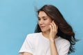 a close portrait of a beautiful depressed brunette woman with hair blowing in the wind during a telephone conversation