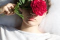 Close portrait of beautiful girl in bed with peony Royalty Free Stock Photo