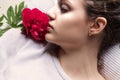 Close portrait of beautiful girl lying with red flower Royalty Free Stock Photo