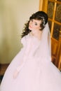 Close portrait of beautiful smiling bride woman with long curly hair posing in wedding dress at interior and smiling. Royalty Free Stock Photo