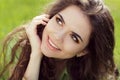 Close portrait of beautiful young woman on green grass in the summer outdoors