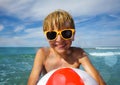 Close portrait of a boy in sunglasses with color inflatable ball Royalty Free Stock Photo