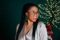 Close portrait of cheerful young African American woman smiling near Christmas tree Royalty Free Stock Photo