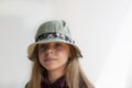 Close. The girl is 11 years old. Portrait of a cute girl with dark long hair. Dressed in a hat. Child teenager. On a white backgro