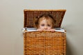 Close portrait of a girl play hide-and-seek in laundry box Royalty Free Stock Photo