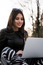 Close portrait of gorgeous dark-hair woman student using laptop computer at campus, charming female teenager studying on Royalty Free Stock Photo