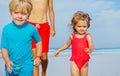 Close-up of three children boys and girl run on sand beach Royalty Free Stock Photo