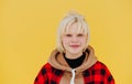 Close portrait of hipster girl with blond hair on yellow wall background, looking at camera and smiling Royalty Free Stock Photo